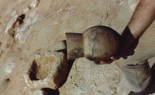 Figure xviii) A water-jar from the residential area, with a stone basin in the background.