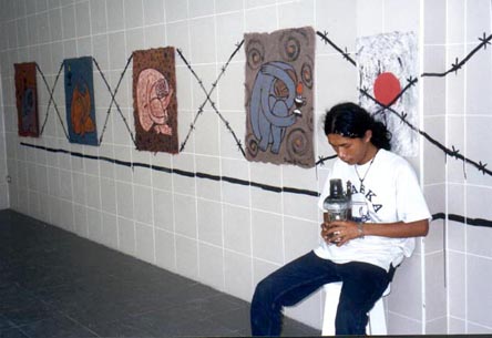 Row of paintings with barbed wire painted onto the wall