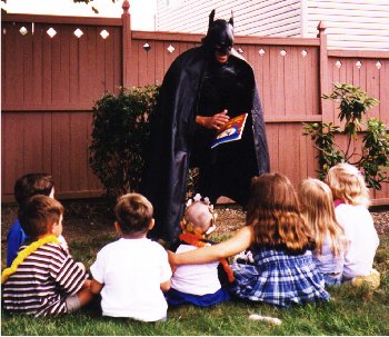Batman captivates the children with magic tricks